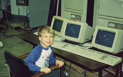 Young Ben sitting in front of computers at his father's workplace
