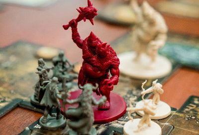 Tabletop boardgame figures attack a huge red monster