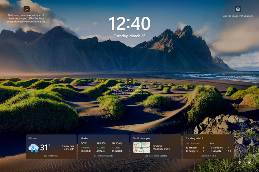 An example of weather, finance, traffic, and sports cards on the Windows 11 lock screen. The cards are aligned in the center and located in a row on the bottom of the screen.