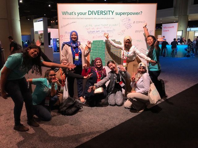 Happy attendees from around the world at the Diversity Superpower wall where people began writing inspiring quotes after all the buttons were gone!