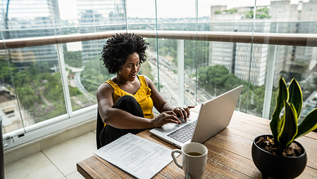 a person at home working using laptop in the apartment balcony