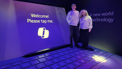 Microsoft MVPs, Kirsty McGrath and Daniel Anderson, demonstrate Copilot on a giant Surface Pro.