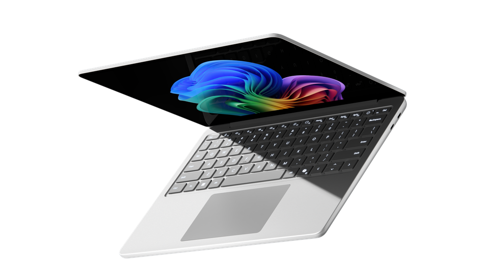 Surface Laptop for Business, 13-inch shown partially open from an overhead angle, highlighting the backlit keyboard, large touchpad, and vivid PixelSense™ display with Copilot+ PC wallpaper.
