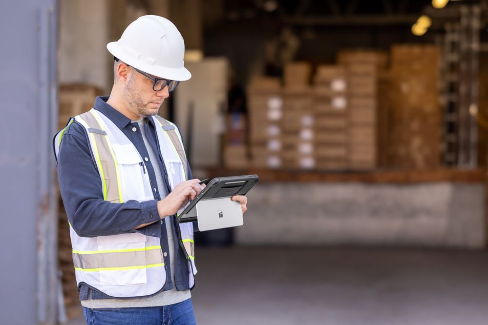 Image of a man in a hardhat and hazard vest using Surface Pro 12-inch