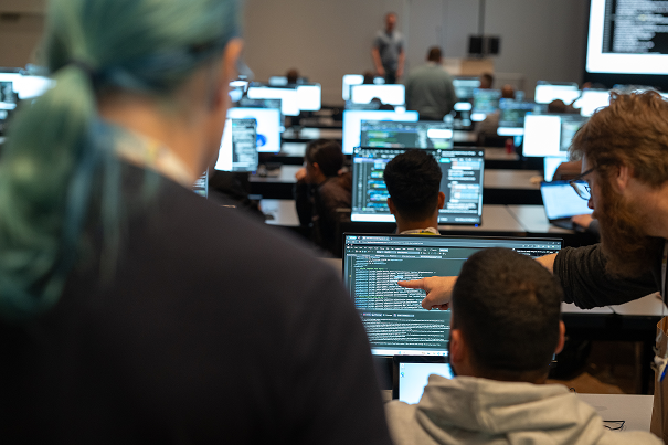 People looking at computer screens with code