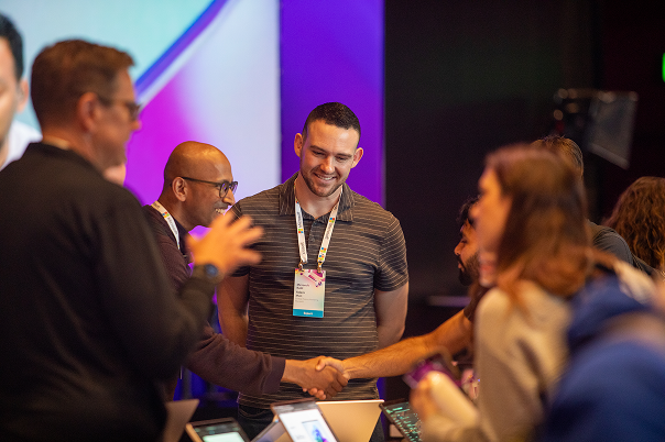 A man shaking a woman's hand with other people around them