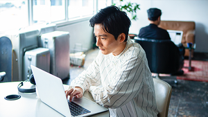 IT Pro sitting at table on their lap top