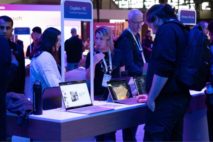 Two women talking to each other while looking at computers