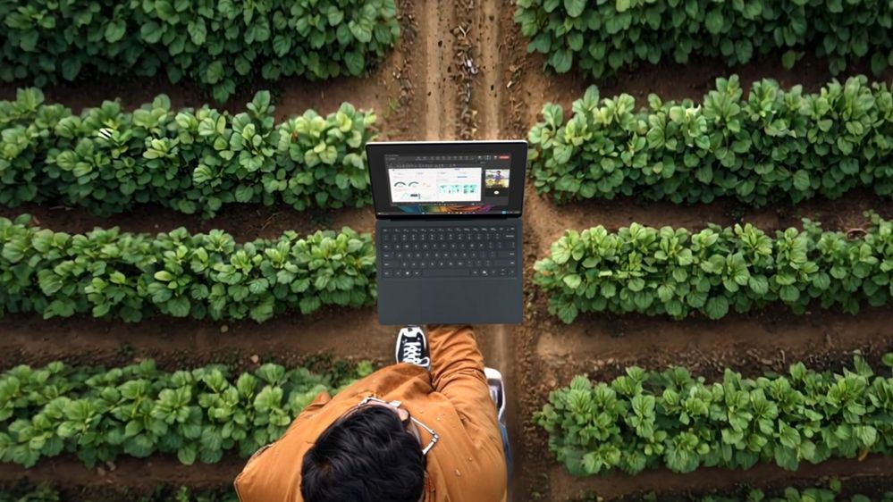 Person walking through field with a 5G-enabled Surface device.