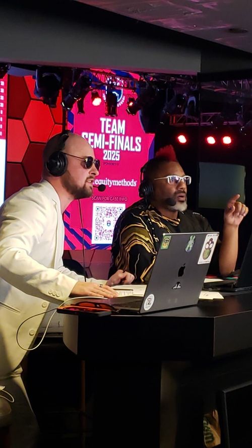 A picture of two men wearing headsets with a laptop computer giving commentary on the Microsoft Excel World Championship