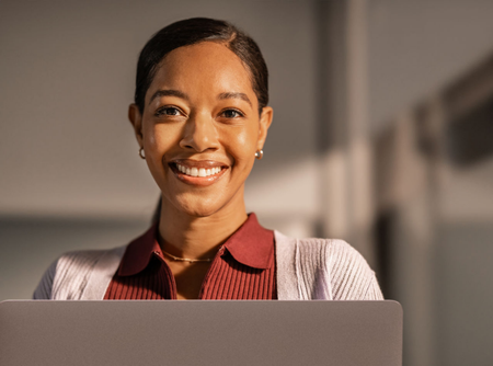 Portrait of an IT professional looking confidently at camera in a moment of focused work.