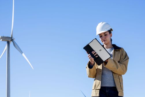 person outside in field worker equipment holding Surface Pro in a ruggedized case