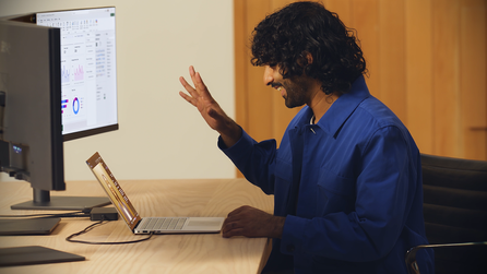 Person waving to another person on video call on laptop