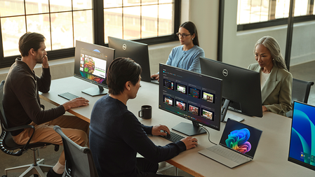 Two men and two women work at workstations in an open office