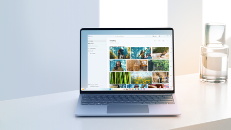 The Photos app is open on a laptop that sits atop a modern desk