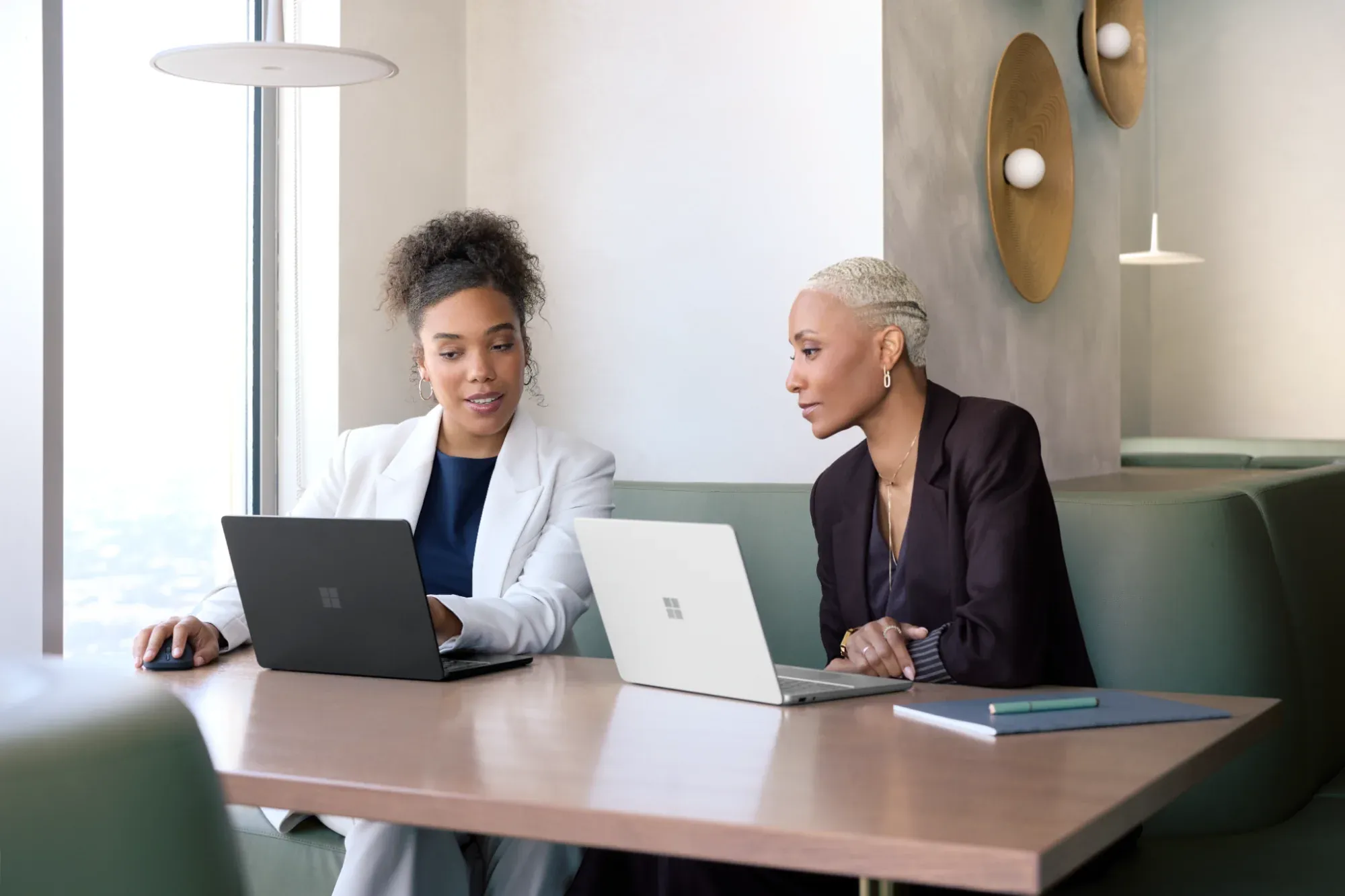 Two people in office environment with Surface devices