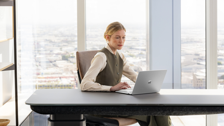 A CIO sitting at desk working on a Surface Laptop.