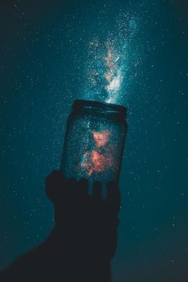 Capturing the galaxy in a clear glass jar. Photo by Rakicevic Nenad.