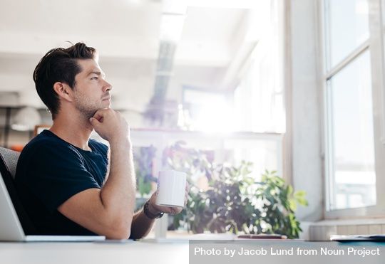 np_Side view shot of young businessman with coffee in hand sitting at his desk_bDVPV5_free.jpg